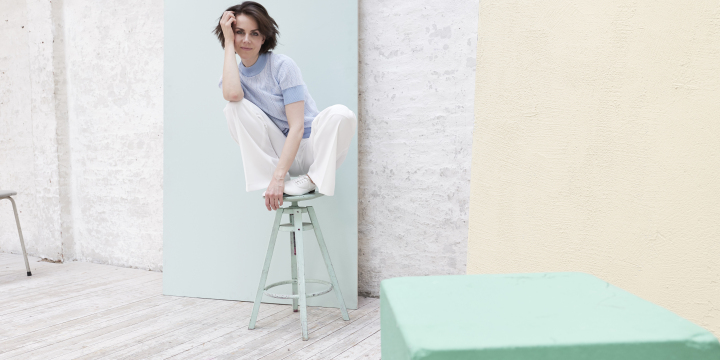 Die Sängerin Anna Deppenbusch in der Hocke auf einem mintfarbenem Hocker und in nachdenklicher Pose, mit dem Kopf auf die Hand gestützt.  ©Steven Haberland